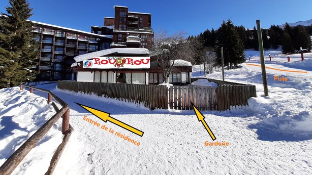A hotel with a sign reading "Club Pou Pou" and a fenced garden area. - Arc 1800 - Studio with balcony overlooking Montblanc, at the foot of the slopes for 5 people. (Bourg-Saint-Maurice)