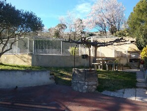 A residential area with a stone wall, a metal fence, and a pergola with a metal railing. - Apt. in the heart of the Alpilles, at the gates of the Camargue (Paradou)