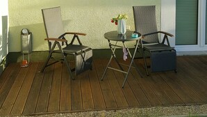 A covered patio with two wicker chairs, a small table with a vase, and a window. - New apartment in the middle of the lake district ideal for active recreation (Blankensee)