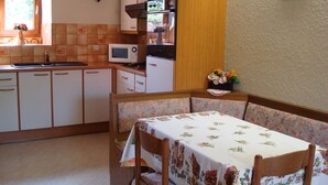A compact kitchen with a dining area. - highland cottage (Grendelbruch)