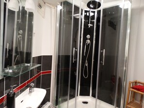 Een douche, een haardroger, handdoeken, toiletpapier
