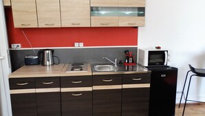A compact kitchen with a central island, a microwave, a kettle, and a coffee machine. - Beautiful studio between Chateau and Loire (Saumur)