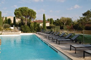 A swimming pool with lounge chairs and a stone building in the background. - Apartment in charming country stone house with pool in Gordes, Luberon (Gordes)