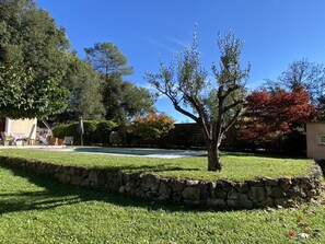 A stone wall, a lawn, and a tree with red leaves. - Magnificent 4-bedroom family villa in the heart of the Côte d'Azur (Roquefort-Les-Pins)