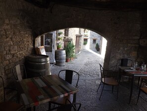 An outdoor café with stone walls, rustic wooden furniture, and a cobblestone path. - APARTMENT AT THE X FEET OF THE SLOPES MOUNTAIN VIEW WITHOUT OPPOSITE (Aragnouet)