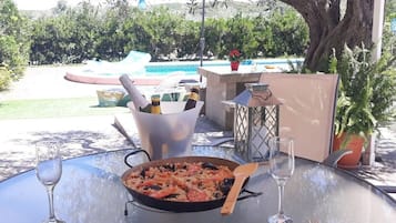 Une table à manger avec un plat de fruits de mer, des verres à vin et une bouteille de champagne.