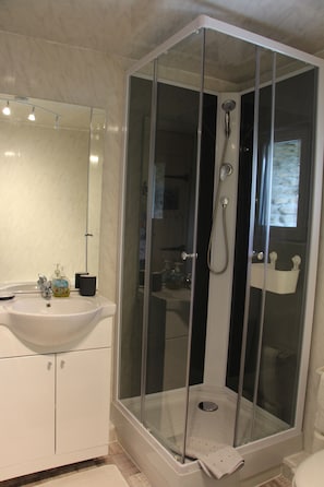 Een bad/douchecombinatie, handdoeken, toiletpapier