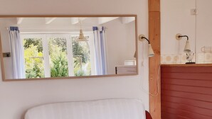 Ein Zimmer mit einem weißen Sofa, blauen Kissen, einem weißen Couchtisch und einem Steinboden.