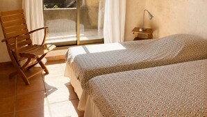 A room with a bed, a chair, a desk, and a view of the sea. - 200 meters from Aiguebelle beach -superb view of the islands- private Jacuzzi (Le Lavandou)