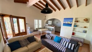 A living room with a sofa, a dining table, and a kitchen area. - The perfect holidays Villa - great views - Beach near by.  (Altea)