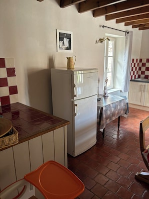A compact kitchen with a refrigerator, a window with a curtain, and a tiled backsplash. - Family gîte with heated indoor pool on the Opal Coast (Tingry)