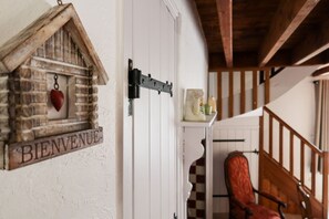A wooden door with a 'BIENVENUE' sign, a heart-shaped decoration, and a metal latch.