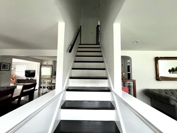 Eine Treppe mit schwarz-weißen Stufen, die zu einer Zwischenebene führen.