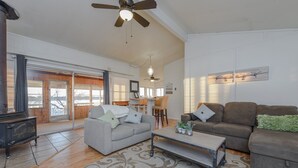 A spacious living room with a sofa, a coffee table, and a ceiling fan.