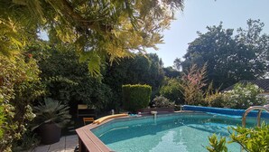 Ein Whirlpool, umgeben von üppiger Vegetation und einer Holzterrasse.