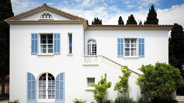 A white building with blue shutters, a tiled roof, and a stone-paved courtyard. - Charming Mas for rent by the week  (Arles)