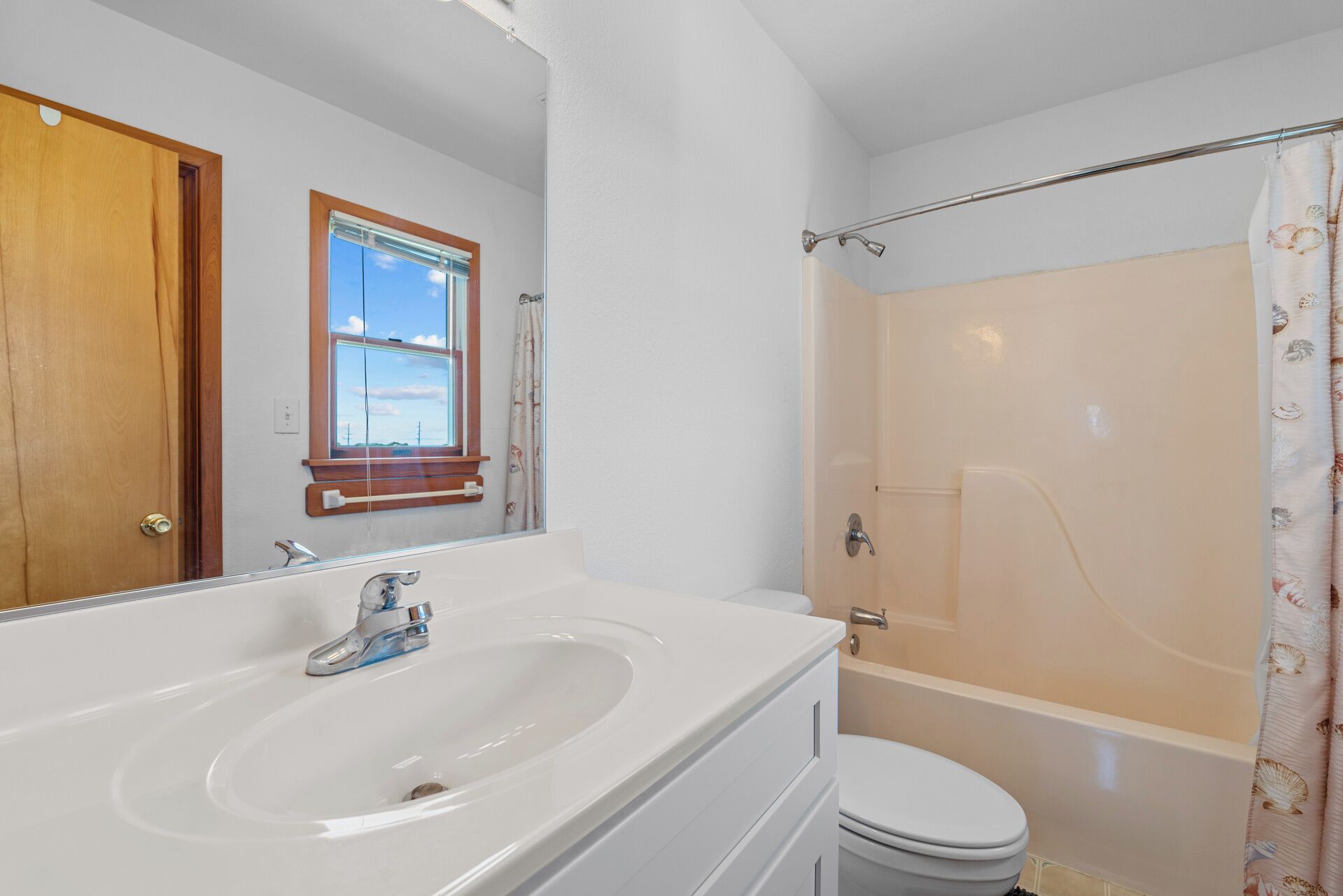 A bathroom with a white sink, a toilet, and a shower.