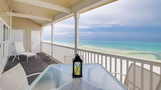 A covered balcony with a glass table, white chairs, and a lantern. - Right on the Beach! Sleeps 10
7 day rentals incl. setup of 4 chairs/2 umbrellas (Seagrove Beach)