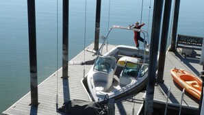 A dock with a covered boat area, a small boat, and a kayak.