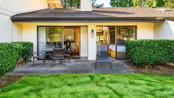 A modern house with a patio, a dining area, and a bedroom with a sliding glass door.