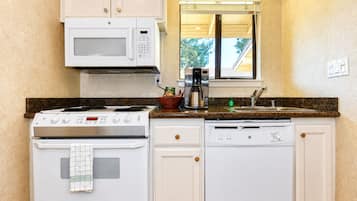 A compact kitchen with a microwave, stove, oven, and dishwasher.