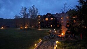 Un gran lodge de varios pisos, con zona de estar exterior y un pozo de fuego.