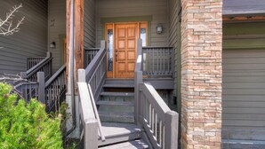 A wooden staircase leading to a front door with a stone pillar on the right. - Hot Tub. Awesome Views. Close to ski areas. Garage. Fully Stocked Kitchen. (Silverthorne)