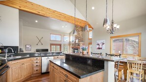 A spacious kitchen with wooden cabinets, granite countertops, and a central island. - Hot Tub. Awesome Views. Close to ski areas. Garage. Fully Stocked Kitchen. (Silverthorne)