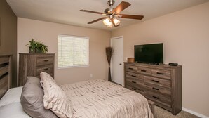 A bedroom with a bed, a ceiling fan, a dresser, a television, and a window with blinds. - GREAT condo rental conveniently located in Mesa/Phoenix   (Mesa)
