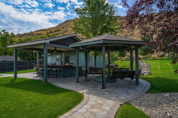 A covered patio area with outdoor seating and a stone pathway.