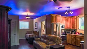 A modern kitchen with wooden cabinets, a refrigerator, and a microwave. - Claim Jumpers Cottage (Baker City)