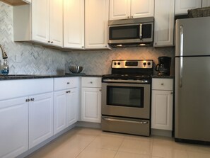 Enjoy cooking in this well-equipped kitchen with a double oven, microwave, and refrigerator.