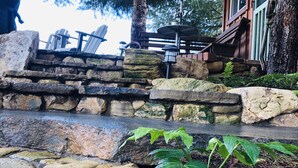 A stone staircase leading to a wooden deck with outdoor seating and a red umbrella. - TREE CABIN FOR 2🌲Unique cabin close to San Luis Obispo, Morro Bay & Paso Robles (Templeton)