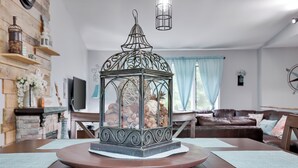 Een eetruimte met een houten tafel, een decoratieve metalen lantaarn en een open haard.