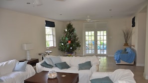 Een woonkamer met een witte bank, een salontafel en een kerstboom.