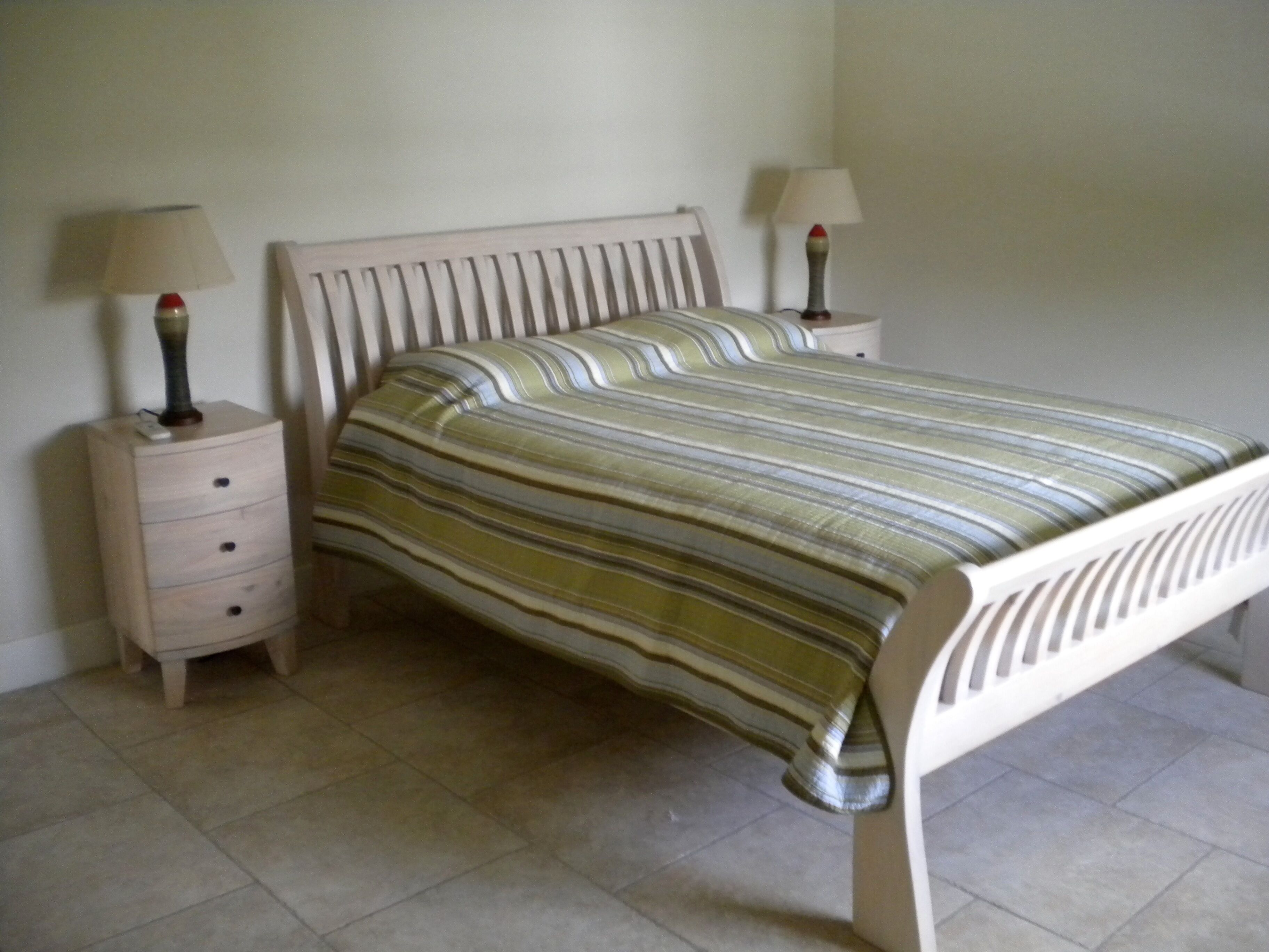 Een slaapkamer met een bed, twee nachtkastjes en een bedbank.