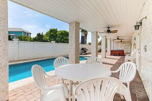 Relax by the pool in this serene outdoor space, featuring a table and chairs, a barbecue grill, and a hot tub.