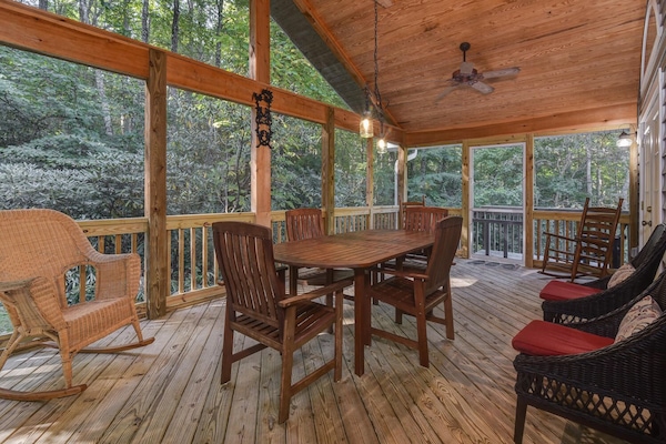 screened in patio with ample seating to enjoy babbling creek running next to it.