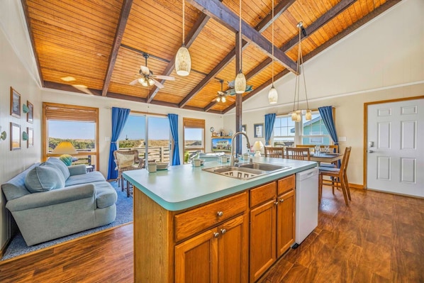 A spacious kitchen with wooden cabinets, a central island, and a dining area with a table and chairs.