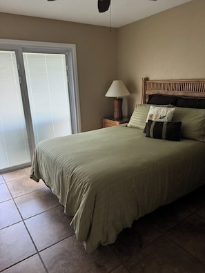 A bedroom with a bed, a nightstand, a lamp, and a sliding glass door. - 2 BEDROOM ON INTRACOASTAL W/ BEACH ACCESS (Nokomis)