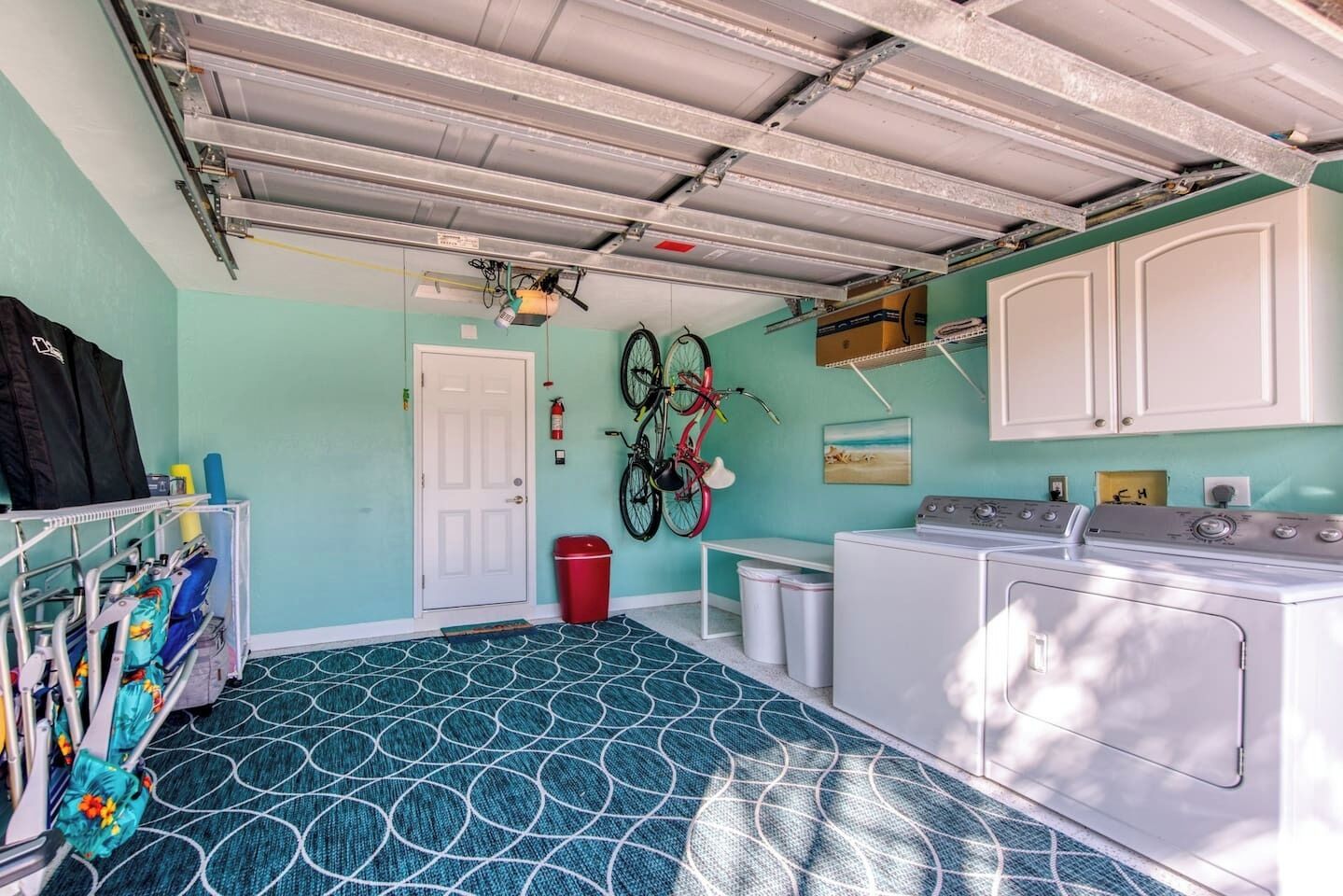 A laundry room with a washing machine, dryer, and two bicycles mounted on the wall.