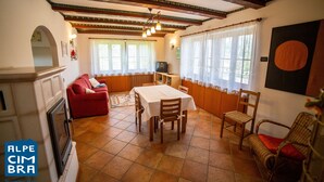 A dining area with a table, chairs, and a red sofa. - Villa Gentilini, nature & comfort (Serrada)