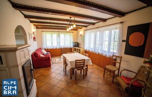 Un coin repas avec une table, des chaises et un canapé rouge.