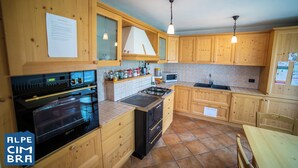 Una cocina con armarios de madera, estufa, horno y microondas.