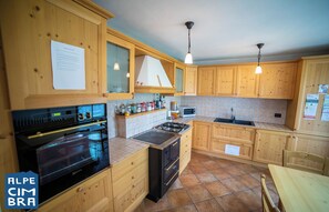 Une cuisine avec des meubles de rangement en bois, une cuisinière, un four et un four à micro-ondes.