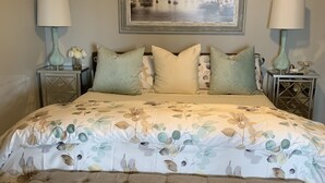 A bedroom with a bed, two nightstands, a bench, and a painting on the wall. - Beaver Lake Get-a-Way          Great Location--Beautiful View (Rogers)