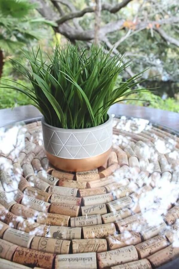 A potted plant on a table with a circular cork coaster design. - Villa Italia "Villas by Christine" (Safety Harbor)