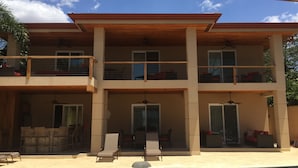 A two-story building with a swimming pool, outdoor seating, and a covered patio area. - Beachfront paradise on Playa Portrero (Potrero)