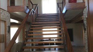 A wooden staircase with a ceiling fan, a potted plant, and a view of the upper floor. - Beachfront paradise on Playa Portrero (Potrero)
