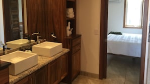 Une salle de bain avec deux lavabos, des meubles en bois et un miroir.